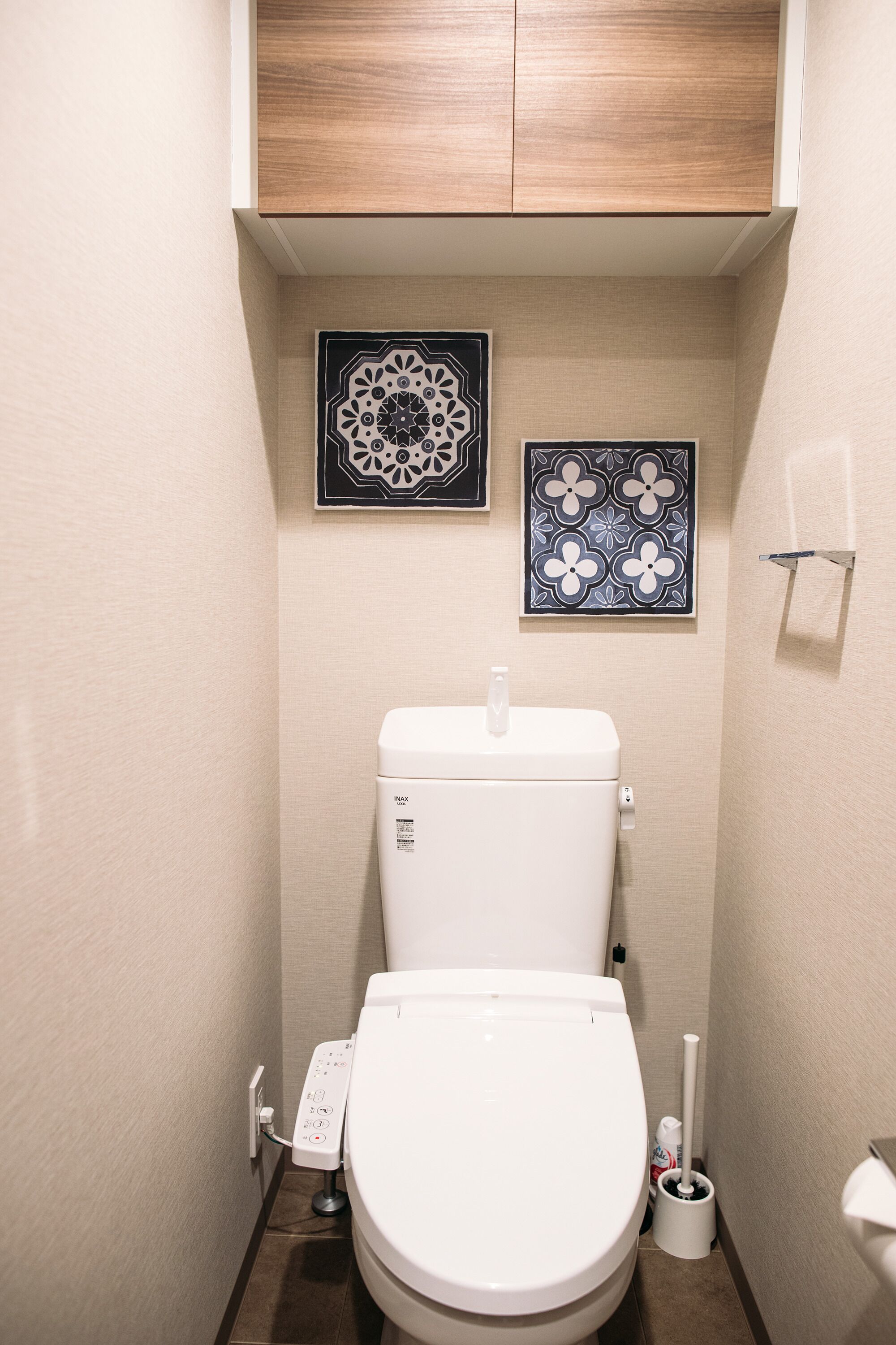 A small, modern bathroom with a toilet, a bidet, and a toilet paper holder.