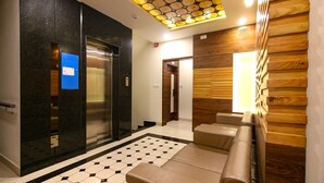 A modern lobby with a checkered floor, a reception desk, and a wooden wall panel.