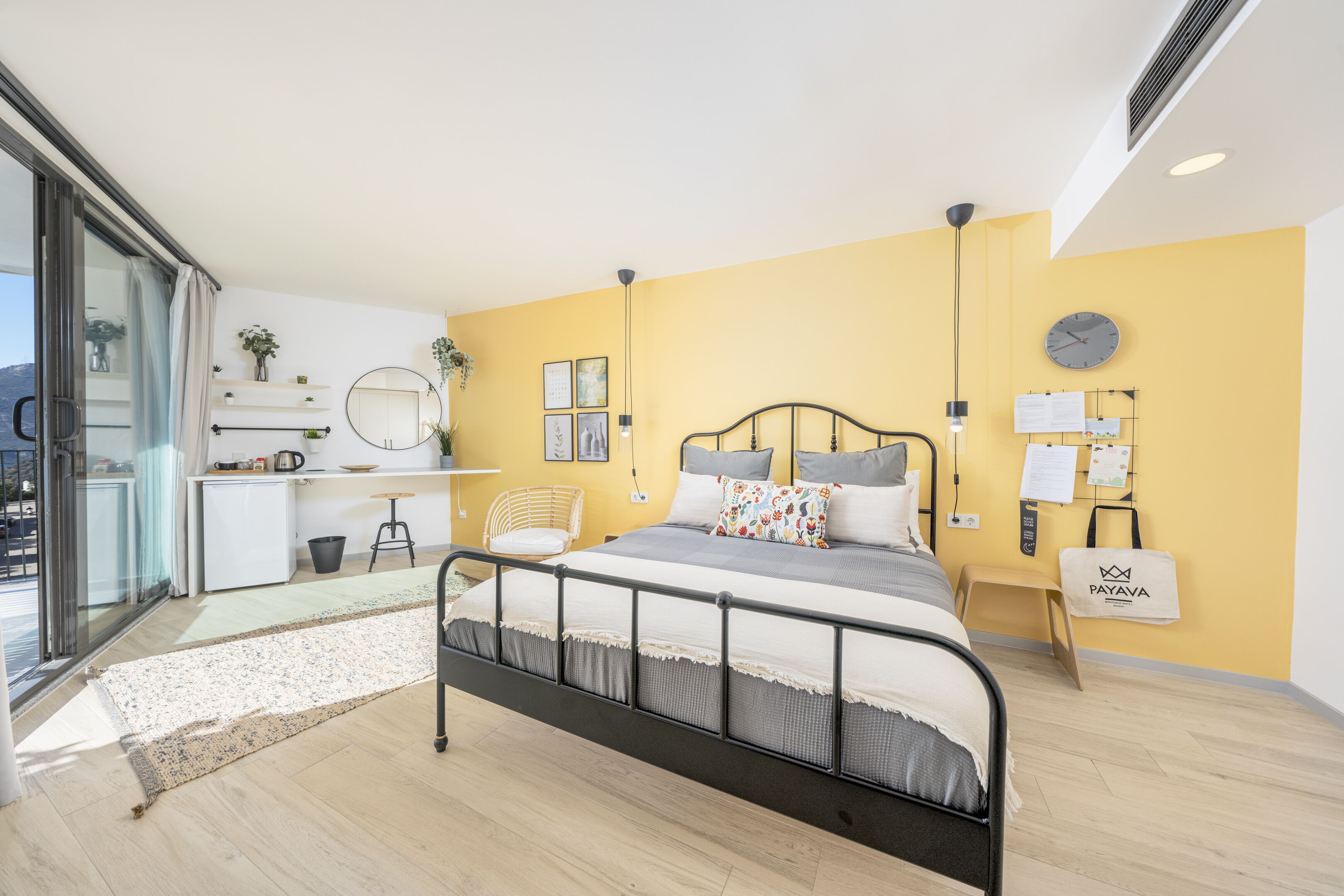 Un dormitorio moderno con una cama, mesitas de noche, un escritorio pequeño y una silla.