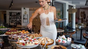 A buffet setup with various food items and a person serving. - Payava Hotel by True Blue (Kas)