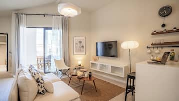 A modern living room with a sofa, coffee table, and a TV mounted on the wall.