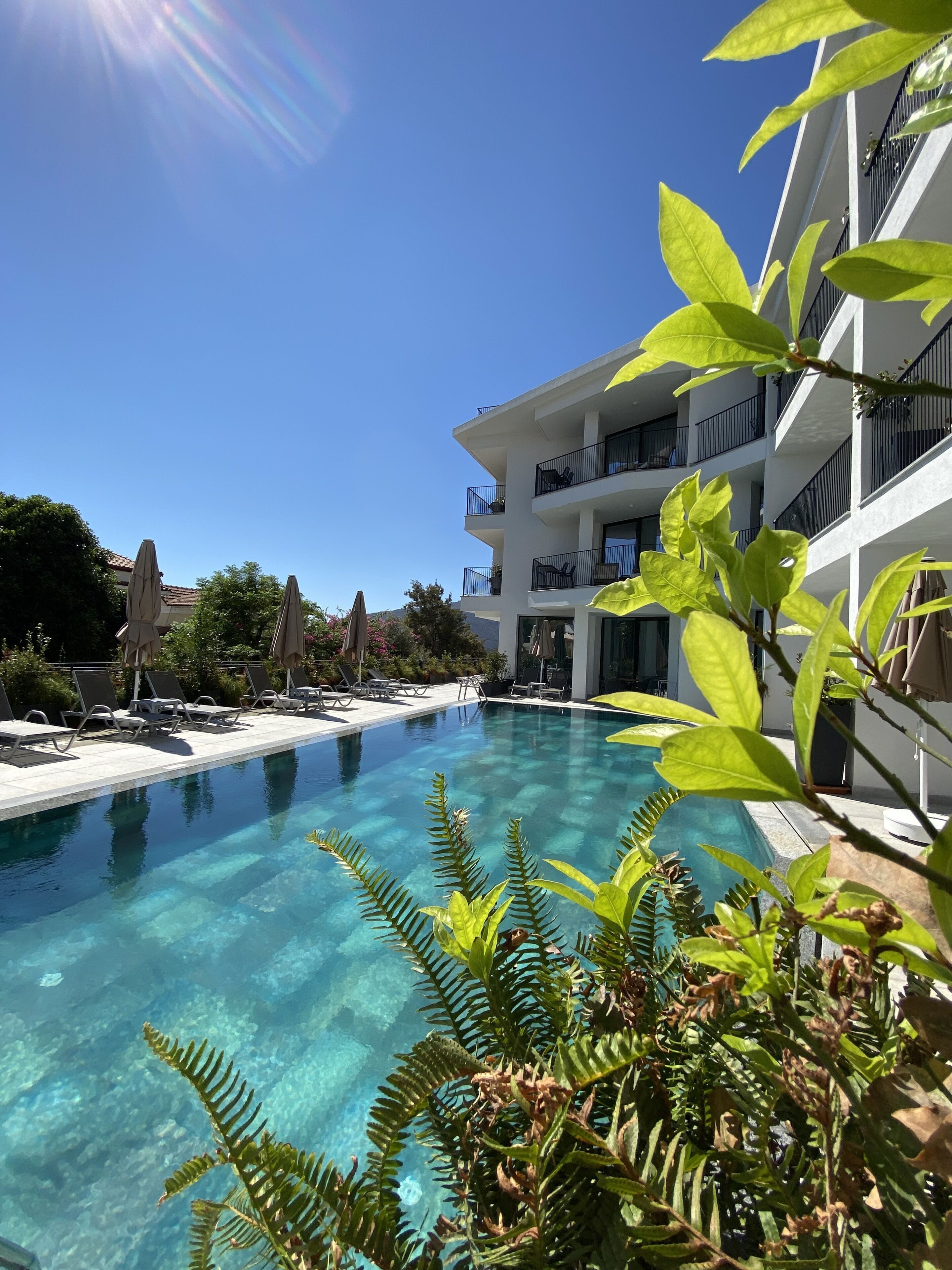 Una piscina al aire libre de temporada, sombrillas