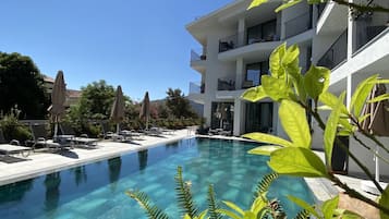 Una piscina al aire libre de temporada, sombrillas