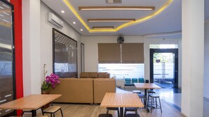 Ein modernes Interieur mit einer Couch, Tischen und Stühlen, die zum Essen eingeladen.
