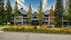 A large, multi-story building with a symmetrical facade, featuring a central entrance with a covered porch.