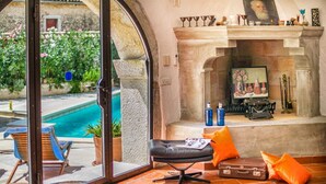 A room with a pool view, a fireplace, a desk with a typewriter, and a leather chair. - Villa Marko (Vrsar)