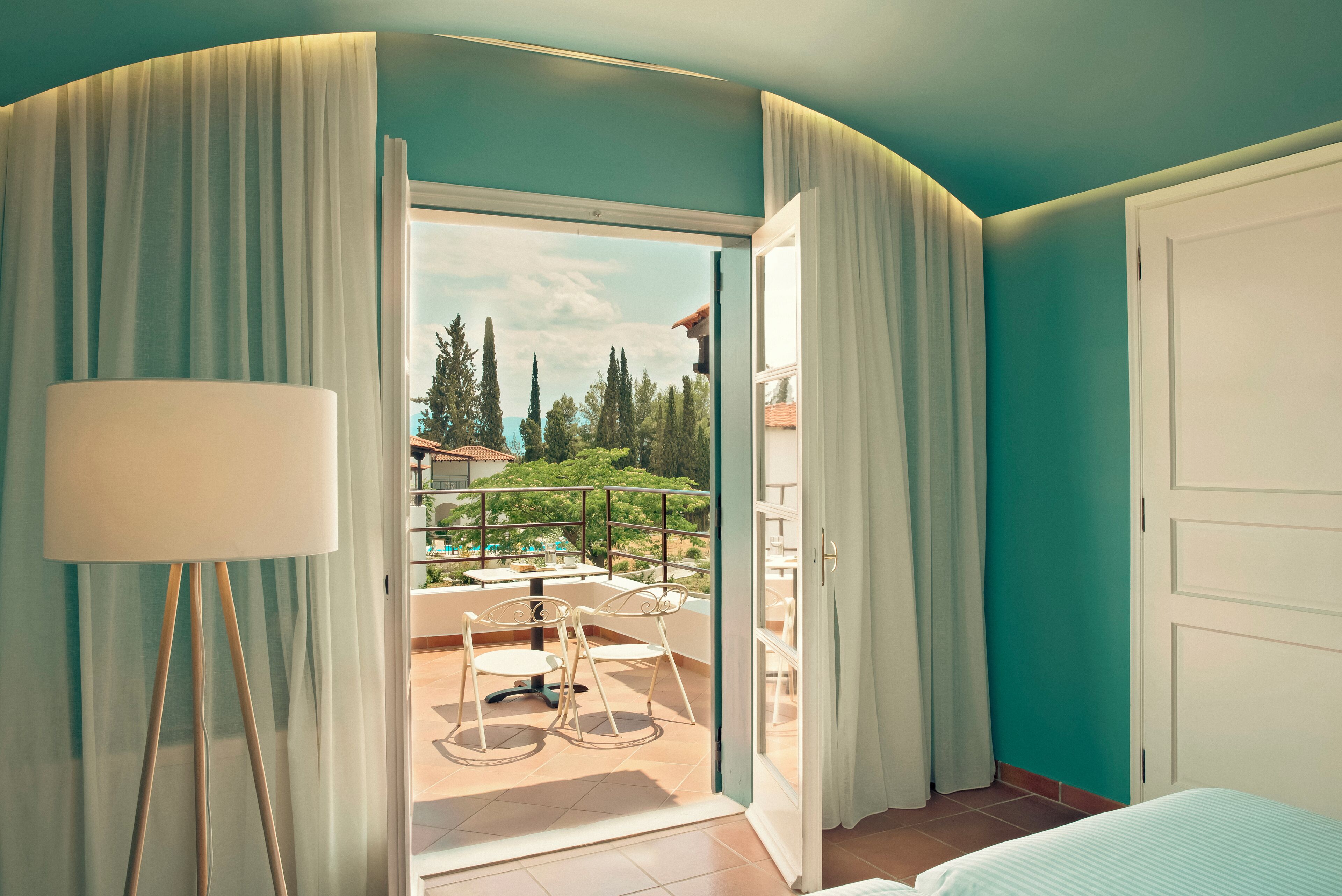 Habitación de hotel con balcón, una cama y vistas al exterior.