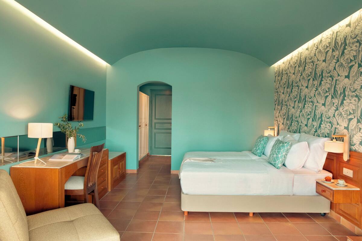 Een moderne slaapkamer met een turquoise kleurenschema, een bed, een bureau en een stoel.
