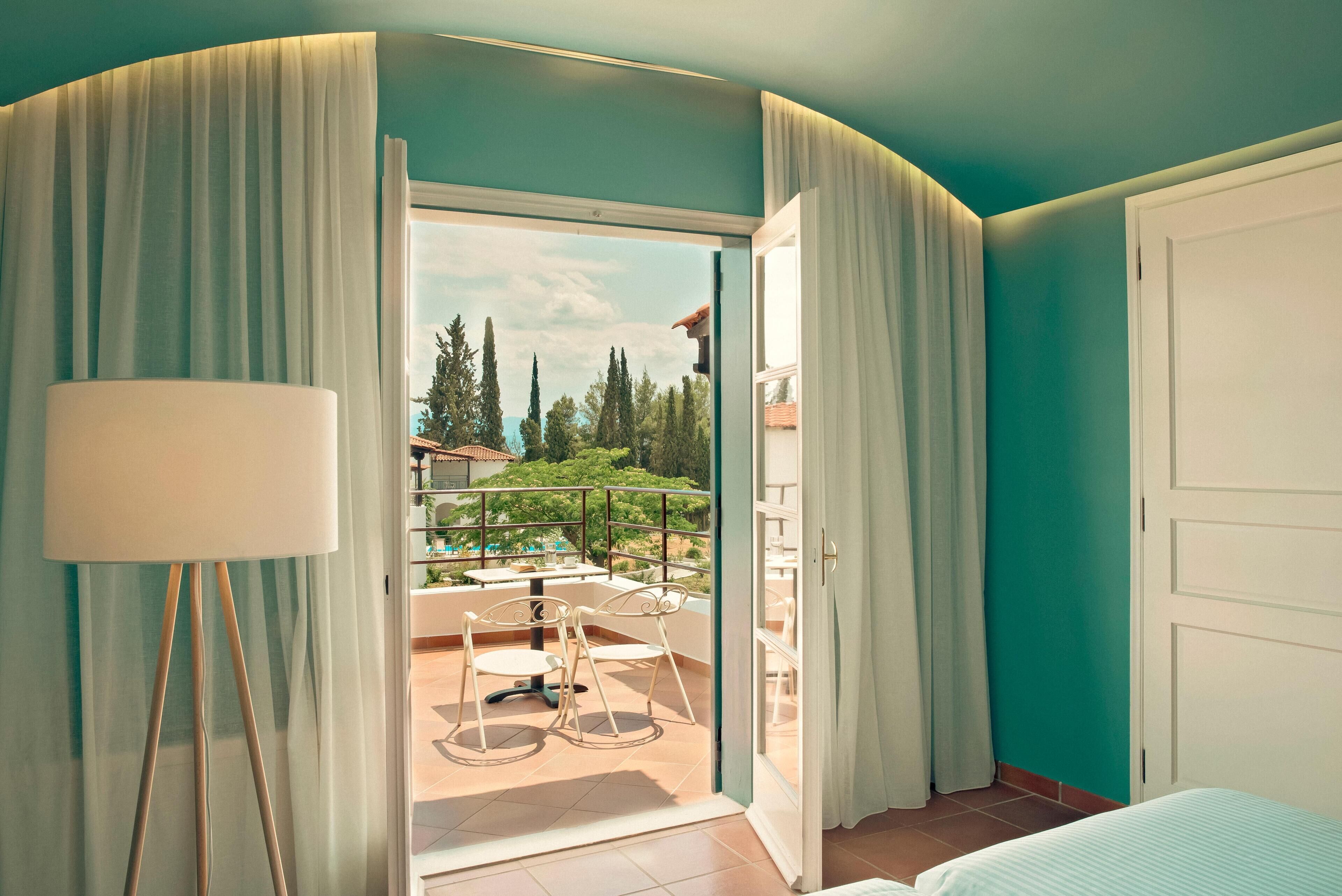 A room with a balcony, a bed, and a lamp.