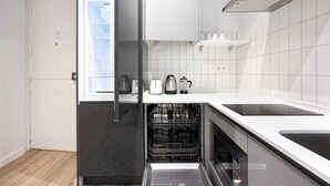 Una cocina moderna con lavavajillas, horno empotrado y fregadero.