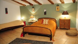 Ein Schlafzimmer mit einem Bett, zwei Nachttischen, einer Lampe, einem kleinen Schrank und einem Teppich.