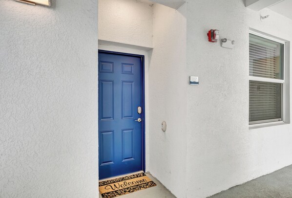 A blue door with a doormat that reads "Welcome". - 2bd/2ba condo close to Disney, Gated community at Storey Lake (Kissimmee)