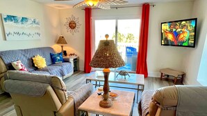 A living room with a sofa, armchairs, a coffee table, a lamp, and a TV. - Gated resort on CSB.End unit w/easy walk to beach. Beach cart & chairs included. (Port St Joe)