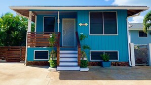 A two-story house with a blue exterior, a front door, a set of stairs, and a small porch area. - Diamond Head/Waikiki Surf Shack 2-Bedroom Private Ohana Unit (Honolulu)