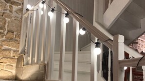 Una scala con ringhiere bianche e luci decorative.