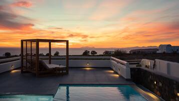 Una piscina al aire libre, sillones reclinables de piscina