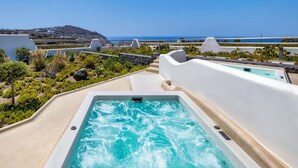 Un jacuzzi con vistas al océano y un paisaje montañoso.