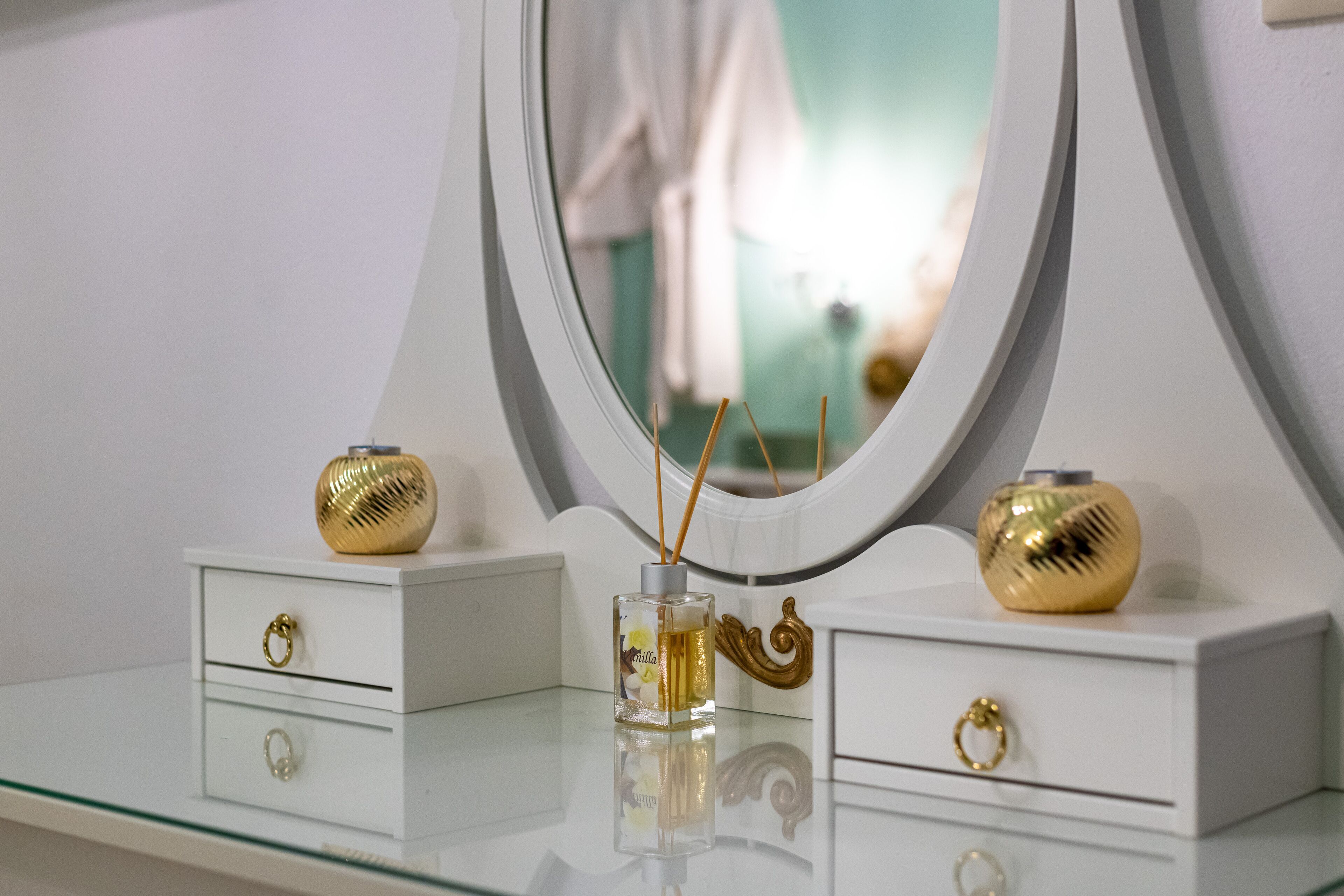 Un tocador de baño con espejo, dos cajones y dos jarrones decorativos.