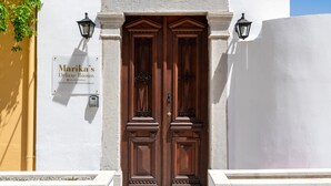 A double wooden door with a sign above it reading "Marika's Deluxe Rooms". - Marikas Deluxe Rooms (Symi)