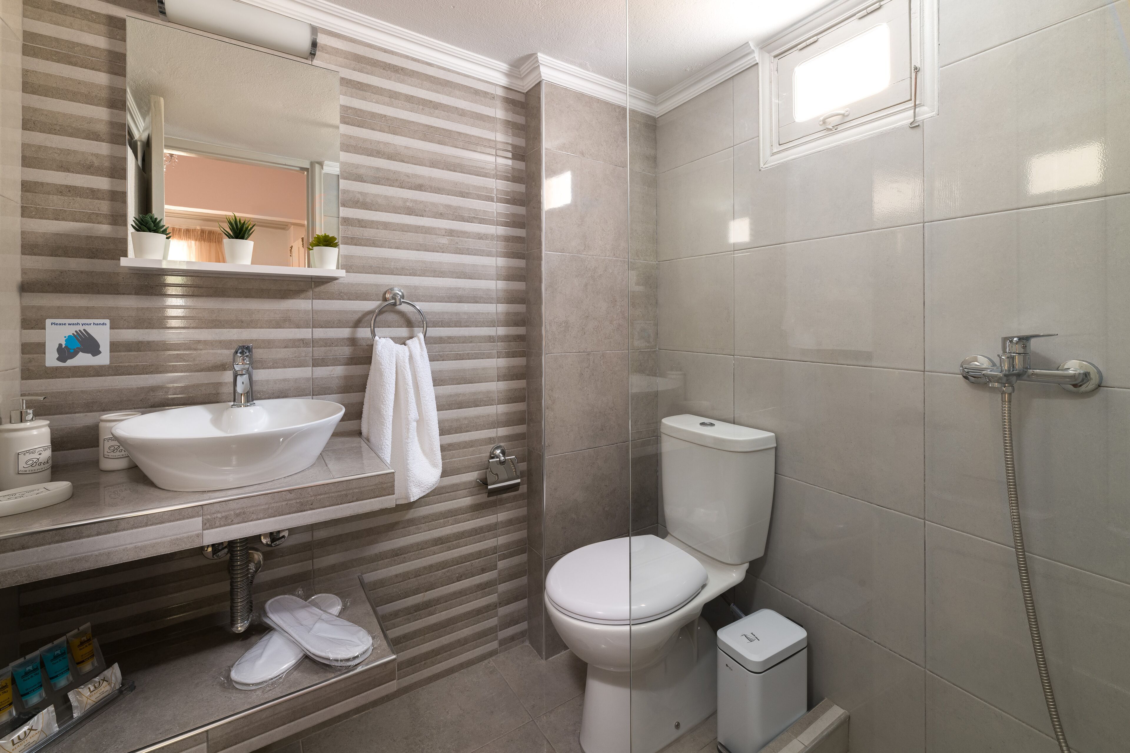 A modern bathroom with a large sink, toilet, and shower.