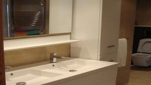 Un bagno moderno con lavandino, specchio e portasciuga in bianco.