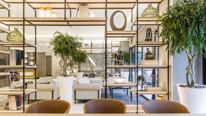 Un interior moderno con una zona de estar central, rodeada de estanterías y objetos decorativos.
