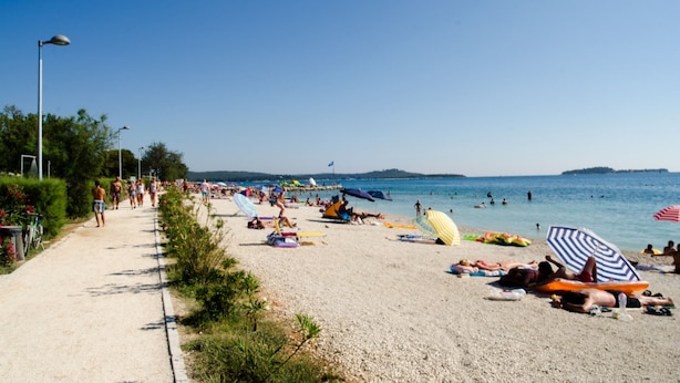 A beach with people sunbathing, swimming, and walking along a path. - Brand new villa with private pool on peaceful location (Vodnjan)