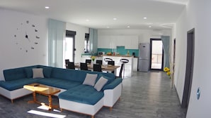 A modern living room with a sectional sofa, a dining table, and a kitchen in the background. - Brand new villa with private pool on peaceful location (Vodnjan)