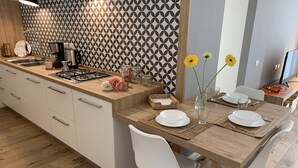 Eine moderne Küche mit einer Holzinsel, weißen Schränken und einer gemusterten Spritzschutzwand.