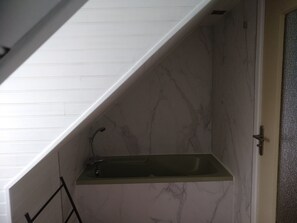 Ein Badezimmer mit Marmorwand, integriertem Waschbecken und Handtuchhalter.