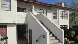 Ein zweistöckiges Gebäude mit einer Treppe zum Eingang.