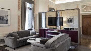 A modern living room with two grey sofas, a coffee table, and a TV mounted on a wall.