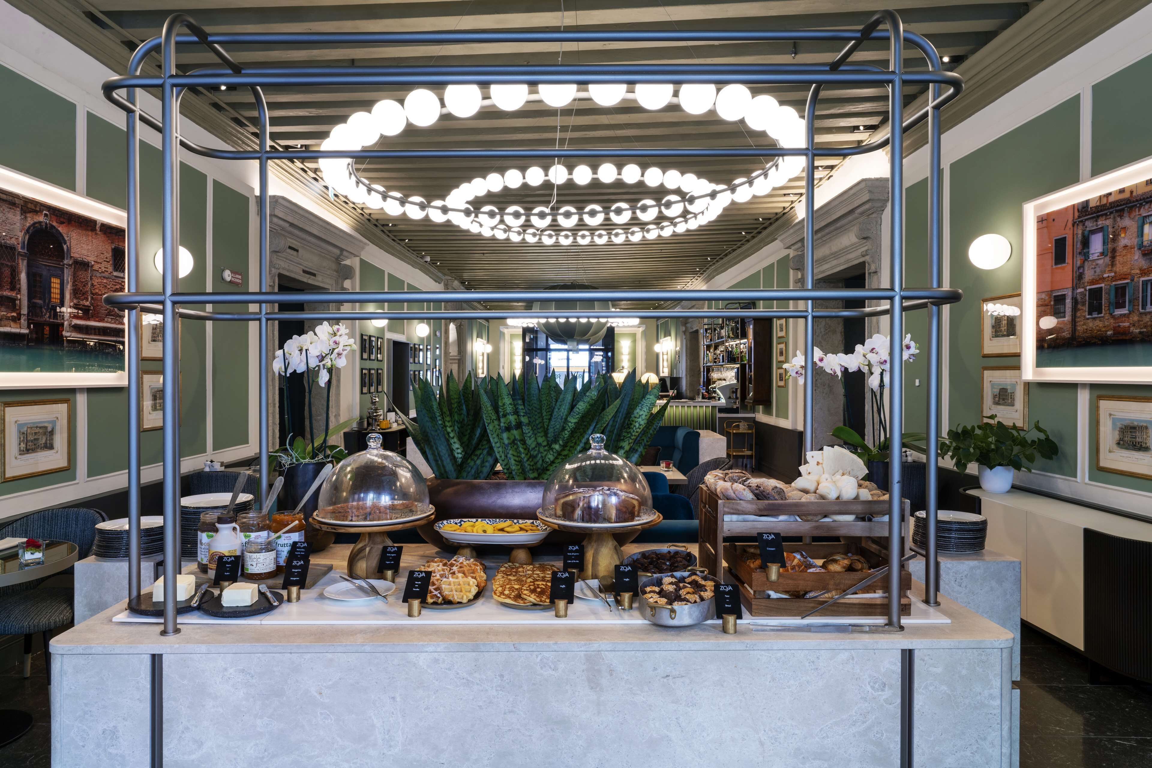 Un buffet proposant une variété de plats et agrémenté d’un luminaire décoratif suspendu au plafond.