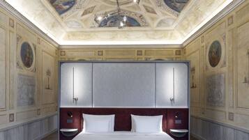Ein luxuriöses Schlafzimmer mit einem großen Bett, einem Marmorkopfschild und einem aufwendigen Deckenfresko.