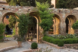 Um arco de pedra com um jardim na frente.