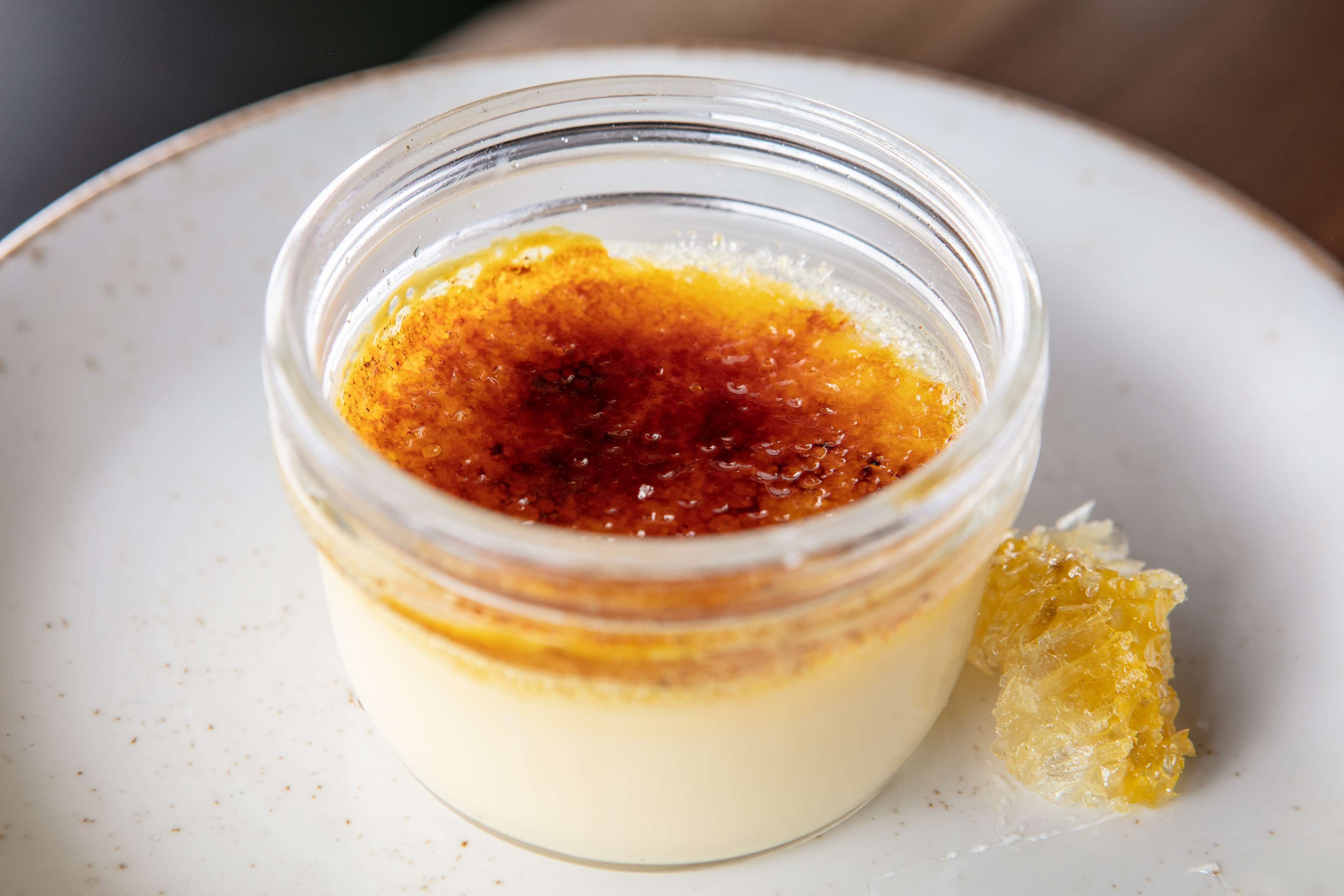 A dessert in a clear glass container on a plate.