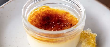 A dessert in a clear glass container on a plate.
