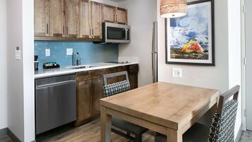 Una cocina moderna con armarios de madera, lavavajillas de acero inoxidable y microondas.