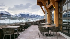 A restaurant with outdoor seating overlooking snow-capped mountains. - Homewood Suites by Hilton Dillon (Dillon)