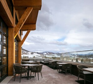 An outdoor seating area with tables and chairs, overlooking a snowy mountain landscape. - Homewood Suites by Hilton Dillon (Dillon)