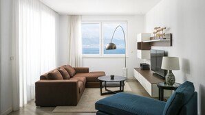 Ein modernes Wohnzimmer mit einer Couch, einem Couchtisch, einem Fernseher und einer Lampe.