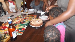 A dining table with a cake, a bottle, and a chessboard. - Compassionate Homestead (Kampala)