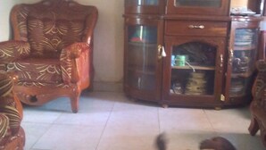 A living room with a wooden cabinet, a television, and a sofa. - Compassionate Homestead (Kampala)