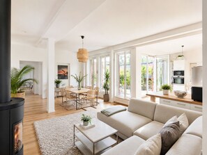 A modern living room with a sofa, coffee table, and a fireplace. - Mauerpark Mitte-Prenzl.Berg Penthouse, modern and authentic. 3 BR, 2 Bath (Berlin)