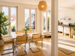A dining area with a table, chairs, and a hanging light fixture. - Mauerpark Mitte-Prenzl.Berg Penthouse, modern and authentic. 3 BR, 2 Bath (Berlin)