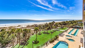 Ein Resort mit Poolbereich, Palmen und Blick auf den Strand.