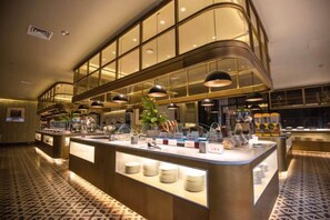 A buffet area with a central island, overhead lighting, and a patterned floor. - Century Plaza Qidu Hotel (Zibo)