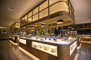 Un área de buffet con una isla central, iluminación colgante y un piso estampado.