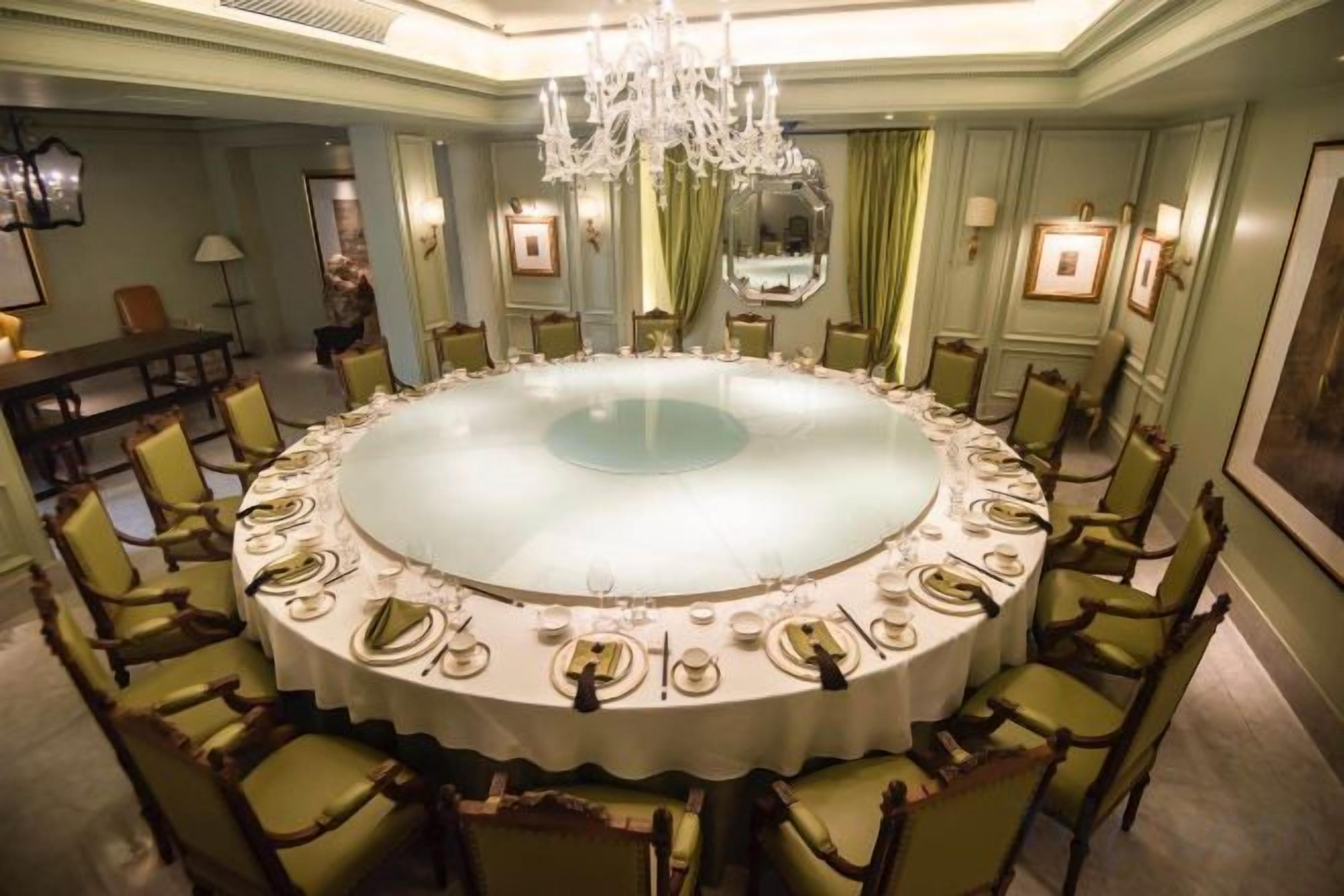 Une table de salle à manger ronde, mise pour un repas, avec des chaises disposées autour.