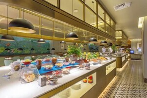 Un bufé con diversas opciones de comida y una barra larga.